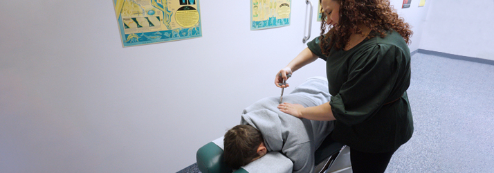 Chiropractor Batavia NY Christina Kulesz Activator Treatment On Patient's Spine For Back Pain Relief